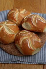Decorated bread rolls on gray striped napkin on wooden table