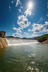Serene waters cascading over a majestic dam in West Virginia under a bright blue sky