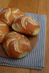 Decorated bread rolls on gray striped napkin on wooden table