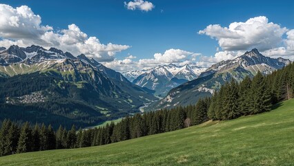 Fototapeta premium Magnificent view of frost-covered mountain ranges complemented by lush greenery and towering evergreens under a serene sky with fluffy clouds.