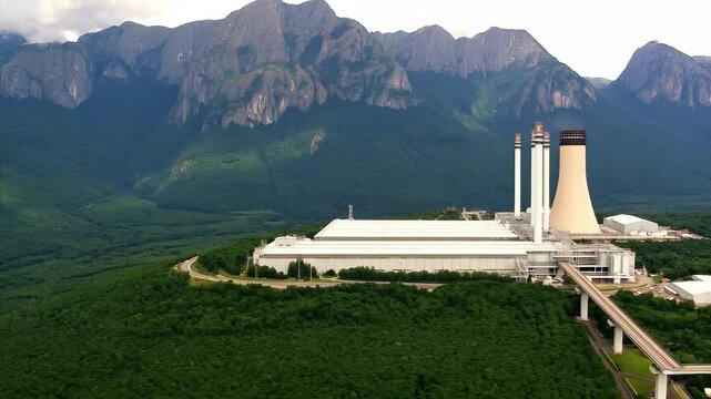 Large industrial plant sits In forested mountains. plant is power plant in ecologically clean area. modern production with provision all environmental safety standards. Responsibility nature concept