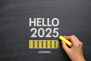 Welcoming the Future A Chalkboard Greeting to 2025 with a Hand Completing the Loading Process