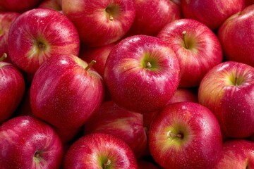 Fresh red apples stacked together showcasing their vibrant colors and water droplets in a market setting