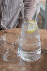 A pitcher filled with refreshing water and a slice of lemon placed inside it