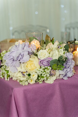 Beautiful floral centerpiece adorns a romantic table setting for a special event celebration in a softly lit venue