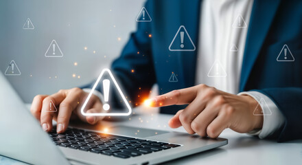 Man in suit working on laptop with digital warning symbols appearing around him, symbolizing cybersecurity threats and system alerts