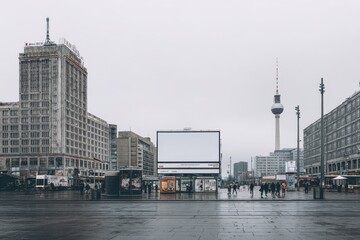 Berlin Alexanderplatz cityscape view with billboard on building, pedestrians moving through central public square
