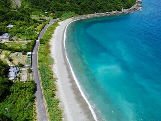 Aerial drone view of Senjojiki on Naru Island, Goto Islands, Nagasaki, Japan – coastal rock terraces, turquoise waters, and lush green landscape under clear summer sky.