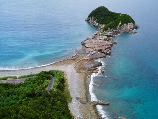 Aerial drone view of Senjojiki on Naru Island, Goto Islands, Nagasaki, Japan – coastal rock terraces, turquoise waters, and lush green landscape under clear summer sky.