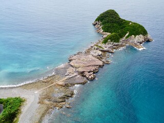 Aerial drone view of Senjojiki on Naru Island, Goto Islands, Nagasaki, Japan – coastal rock terraces, turquoise waters, and lush green landscape under clear summer sky.