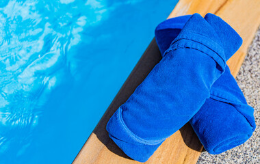 A blue towel is placed by the poolside.