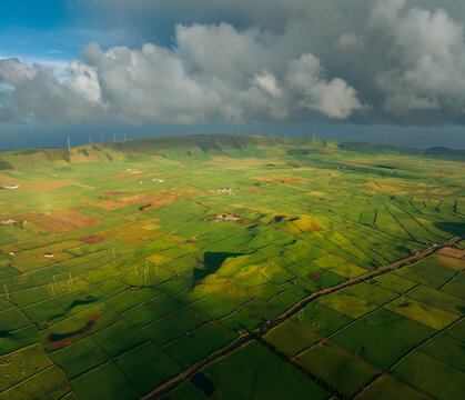 Aerial view of rolling green pastures etched into a patchwork quilt under a dramatic sky at Miradouro da Serra do Cume, Praia da Vit&Atilde;&sup3;ria, A&Atilde;&sect;ores, Portugal.