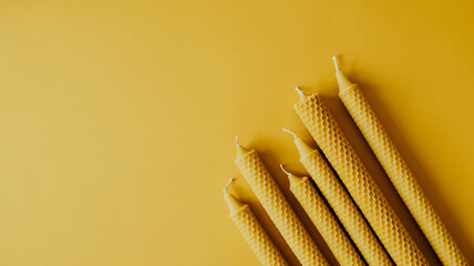 Golden birthday candles arranged on a warm yellow background