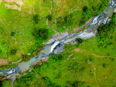 Aerial view of a vibrant river cascading through the verdant landscape, a tapestry of nature's artistry unfolds beneath, Maza village, Jos North, Nigeria.