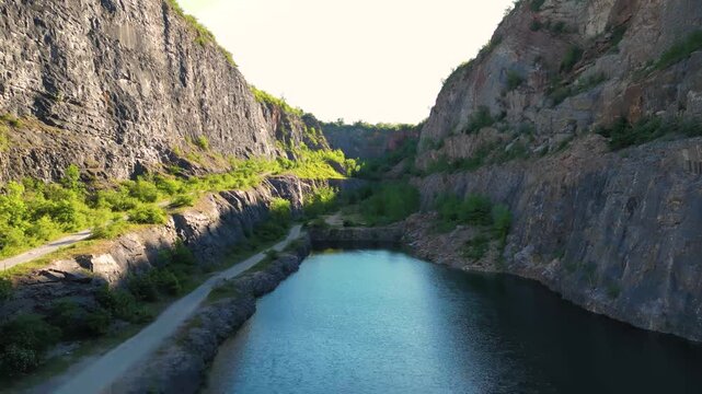 Discover the serene beauty of Velka Amerika, an abandoned limestone quarry near Prague. Here, nature reclaims space with stunning cliffs and a tranquil lake at sunset.