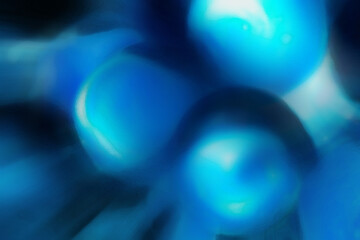 たくさんの青いガラス玉が暗い場所でぼんやりと光る柔らかいタッチの抽象イメージテクスチャー
