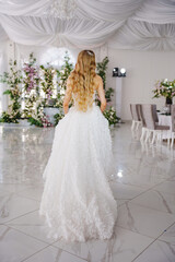 Fototapeta premium A bride in a hall decorated with flowers, decorated with flowers