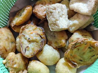 Gorengan, traditional Indonesian street food consisting of brontak tofu, fried banana, bakwan, jemblem, etc. Goes well with green chilies.