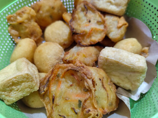 Gorengan, traditional Indonesian street food consisting of brontak tofu, fried banana, bakwan, jemblem, etc. Goes well with green chilies.