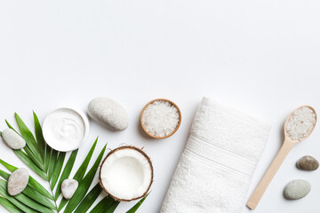 Coconut with jars of coconut oil and cosmetic cream on colored background. Top view. Free space for your text. Natural spa coconut cosmetics and organic treatment concept Coconut Spa composition
