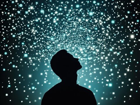 Silhouette of a person gazing upward at a mesmerizing, sparkling, teal light shower.