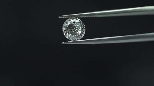 diamond with tweezers closeup micro view in diamond manufactiring unit 