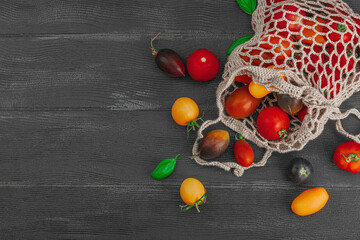 Assortment of various tomatoes in a trendy eco bag. Handmade, crocheted, zero-waste concept