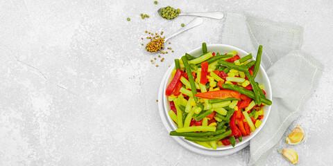 Vibrant frozen vegetable mix with yellow and green beans, red bell peppers, corn. Frosty texture