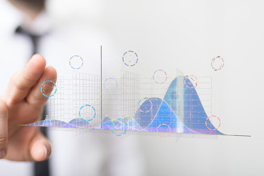 Stock photo of a businessman interacting with holographic financial graphs and charts.