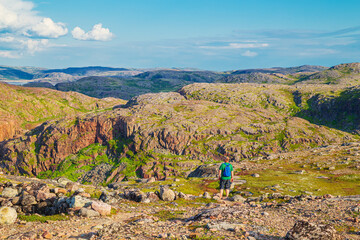 A male tourist in the Teriberka Nature Park on the shore of the Barents Sea.
