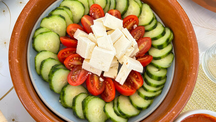 Bandeja con ensalada de pepinos, tomates y queso