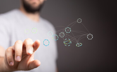 A man's finger interacts with a digital network visualization, representing connection and data flow.