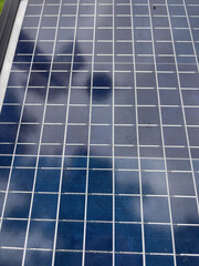 Solar panel surface with grid lines and reflections of clouds, concept of renewable energy, green technology, power, sustainability.