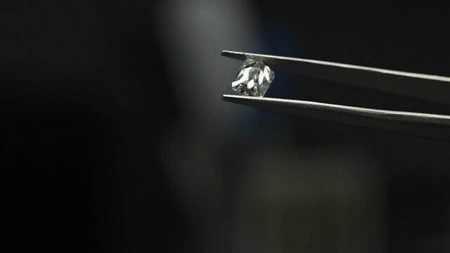 diamond with tweezers closeup micro view in diamond manufactiring unit 