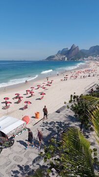 Aerial view of famous Ipanema Beach, lined with palm trees on a bright, sunny day in Rio de Janeiro, Brazil.