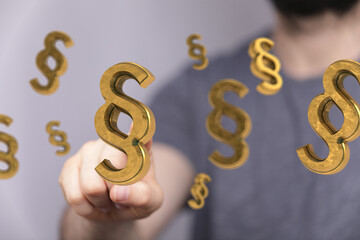 Abstract image of golden paragraph symbols floating, representing legal concepts, law, and regulations.
