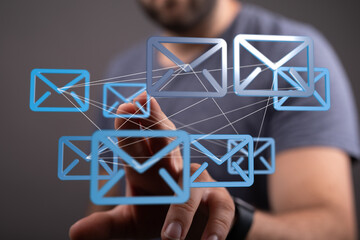 Man interacts with a network of digital email icons, symbolizing global communication and interconnectedness.