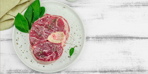 Raw ossobuco beef meat with spices and fresh herbs. Veal shank steak, traditional Italian ingredient