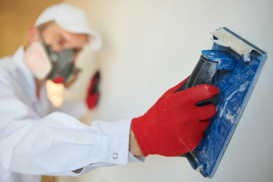 Plasterwork and wall painting preparation. craftsman applying sanding wall