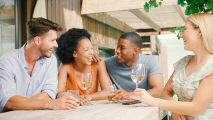 Group Of Smiling Multi-Cultural Friends Outdoors At Home Drinking Wine Together