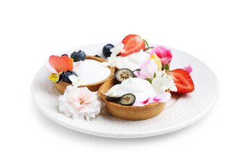 Delicious dessert. Tartlets with cream, berries and flowers isolated on white