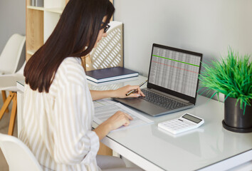 Woman, female accountant calculator looking at laptop screen reporting financial transactions to calculate expenses, expenditures pay bills taxes online, managing home family or company budget 