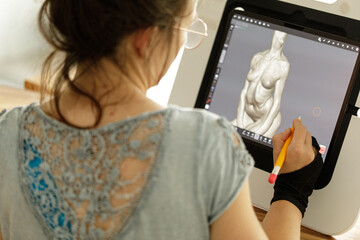 Female artist uses stylus on tablet to create a 3D digital sculpture. Creative process, modern art.