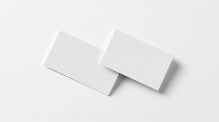 blank white business cards lying flat on a clean white surface, slight shadows creating depth, minimalist style, professional mockup scene