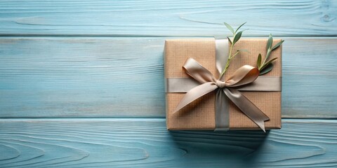 A thoughtfully wrapped gift box, adorned with a delicate ribbon and sprig, rests on a serene blue wood surface