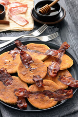 bacon pancakes drizzled with sirup on a plate