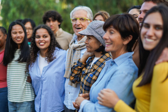 Crowd of multiracial people having fun together at city park - Social gathering and multi generational community concept - Focus on elderly thai woman face