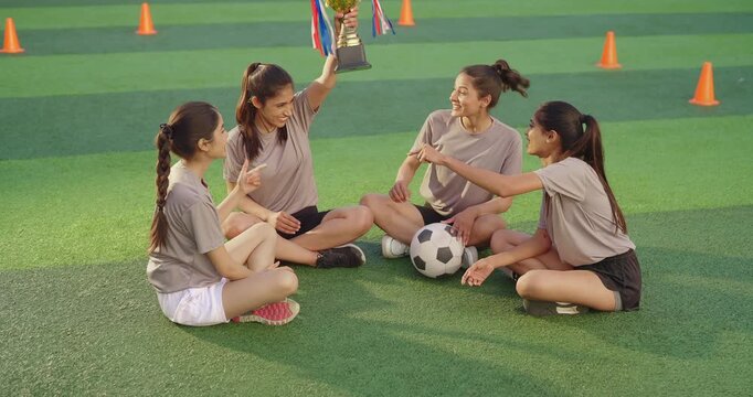 Indian happy young adult gen z lady group take break after talk enjoy day spend time teen female girl team do hug speak win trophy give high five clap hands pick up award cup raise in air have fun joy