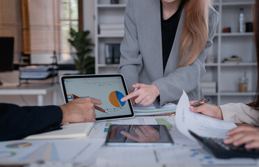 Business team analyzing financial data on a digital tablet, discussing charts and graphs, and collaborating on investment strategies in a modern office setting