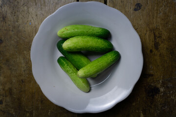 Fresh cucumbers on a white plate, ready to be enjoyed